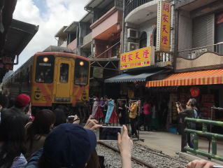 十分商店街を抜ける平渓線列車